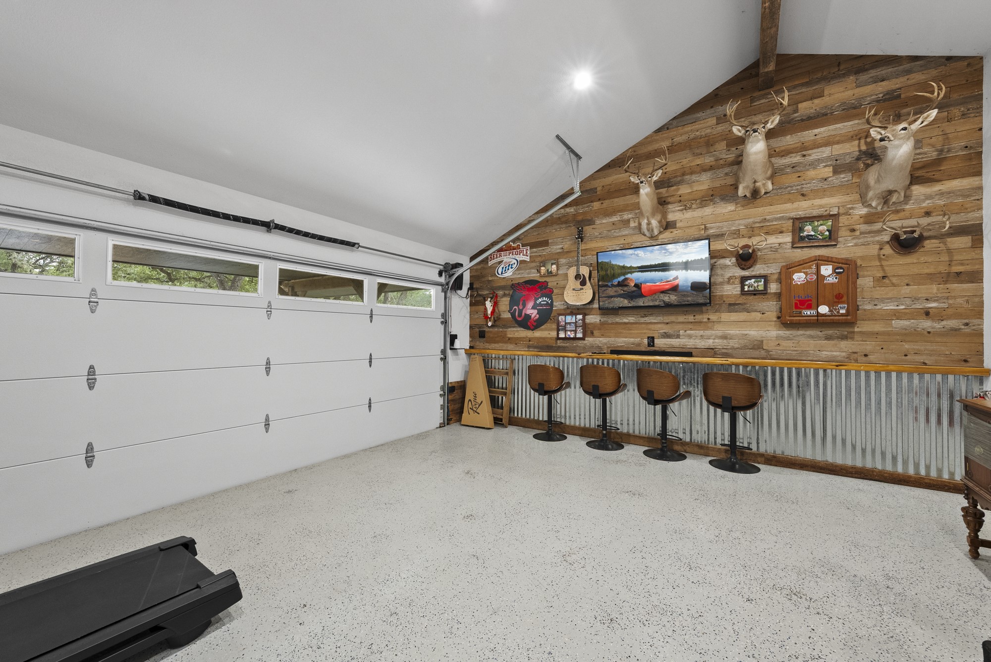 2802 Robin Road Manchaca, TX 78652 - Photo 15 of 40 Garage space featuring a built-in bar with wood-finish countertop, corrugated metal wainscoting, and a wood-plank accent wall