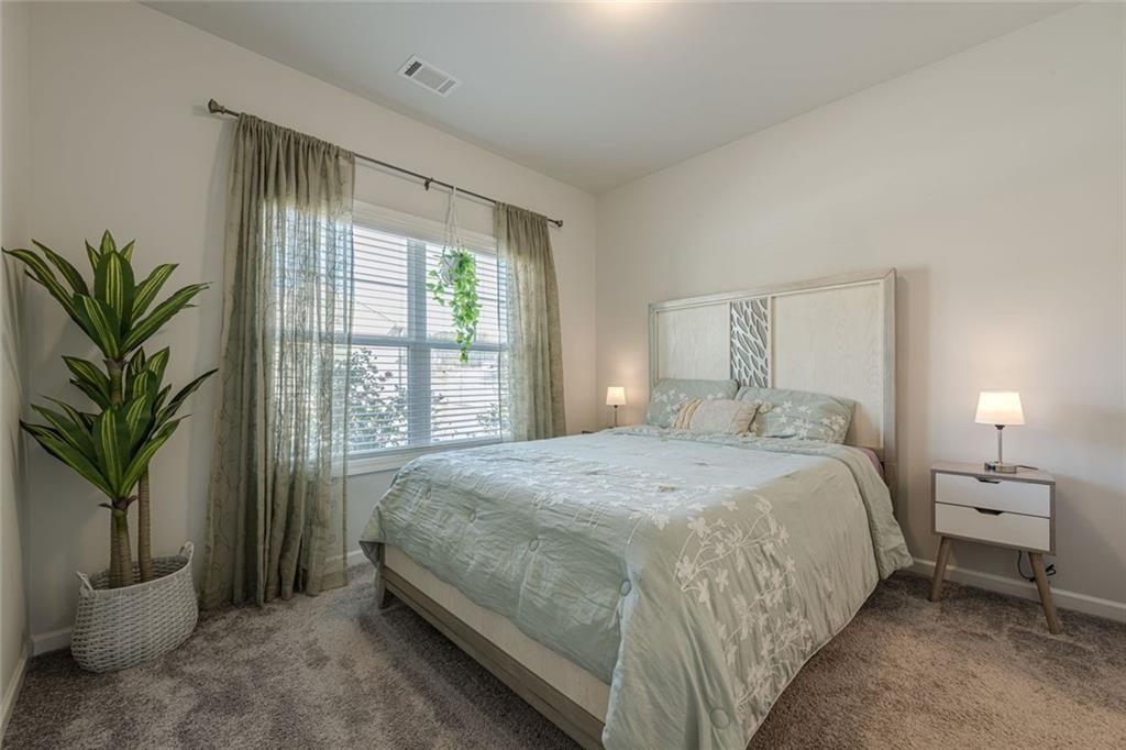 3593 Dover Run Lane Loganville, GA 30052 - Photo 21 of 54 a bedroom with a large bed and a potted plant