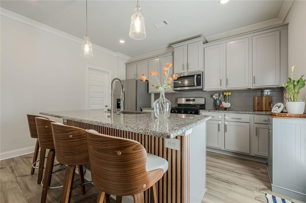 3593 Dover Run Lane Loganville, GA 30052 - Photo 7 of 54 a kitchen with stainless steel appliances granite countertop a table chairs sink and cabinets