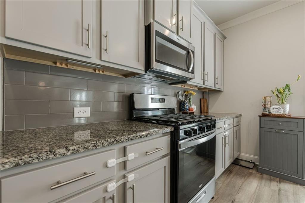 3593 Dover Run Lane Loganville, GA 30052 - Photo 10 of 54 a kitchen with stainless steel appliances granite countertop a stove and a microwave