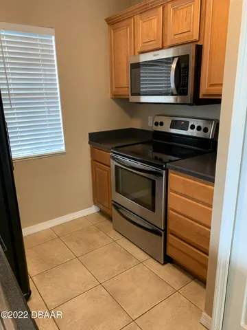 a kitchen with granite countertop a stove top oven microwave and cabinets