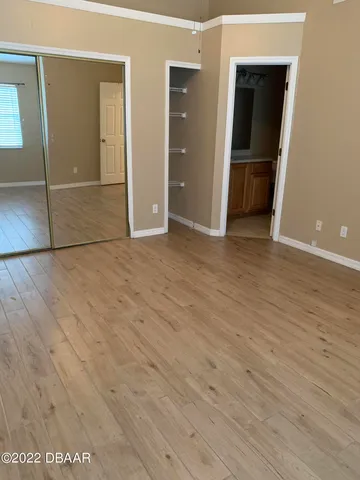 an empty room with wooden floor and closet