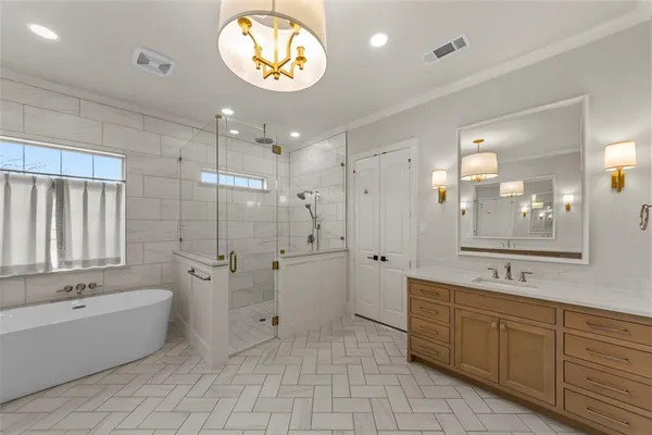a bathroom with a tub a sink and a large mirror
