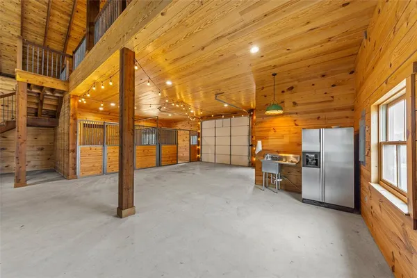a view of a hall with wooden floor and iron stairs