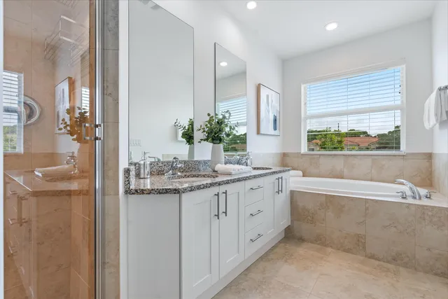 a bathroom with a granite countertop sink and a bathtub