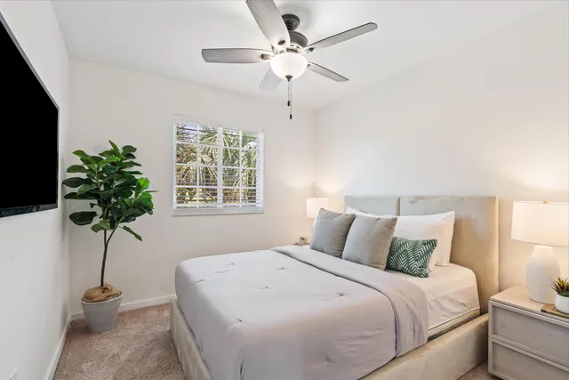 a bedroom with a bed and a potted plant