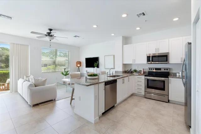 a kitchen with white cabinets and stainless steel appliances