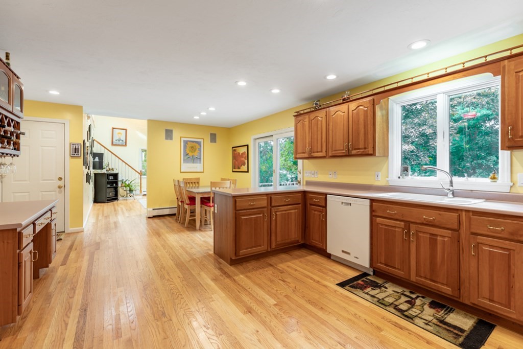 21 Longacre Road Needham, MA 02492 - Photo 12 of 41 a kitchen with stainless steel appliances granite countertop a stove a sink dishwasher and a refrigerator with wooden floor