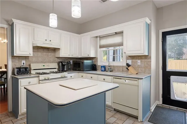 a kitchen with stainless steel appliances granite countertop a refrigerator a stove a sink dishwasher a refrigerator and white cabinets with wooden floor