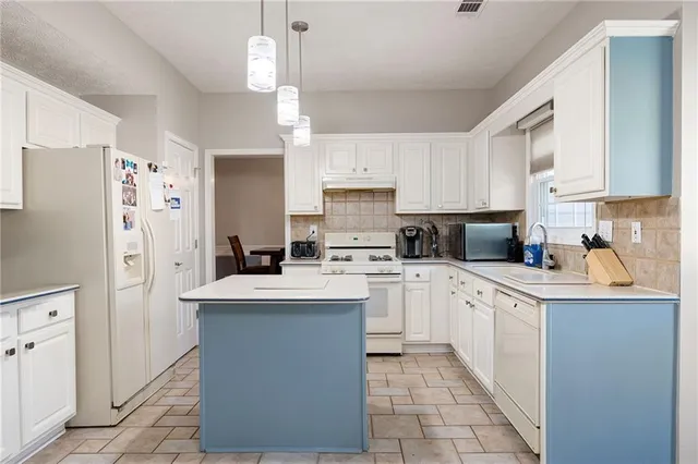 a kitchen with a sink and a stove top oven with wooden floor