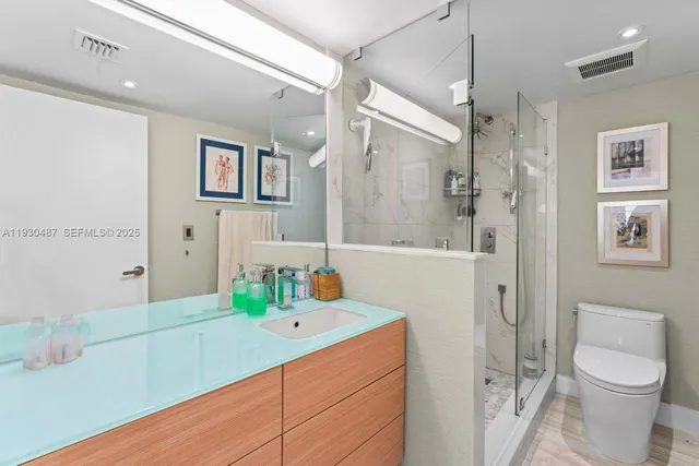 a bathroom with a sink a toilet and shower