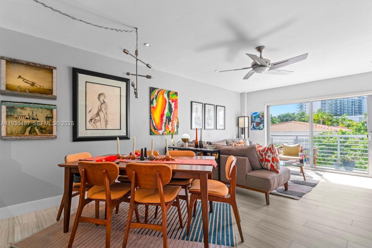 1450 Lincoln Road, Unit 307 Miami Beach, FL 33139 - Photo 4 of 18 a dining room with wooden floor a chandelier fan a wooden table and chairs
