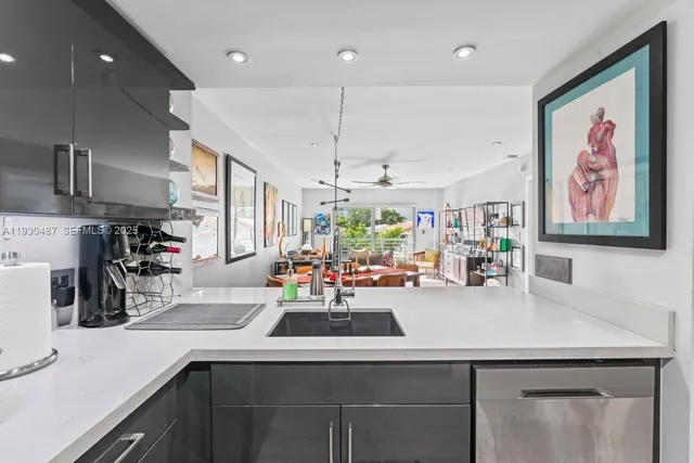 a kitchen with a sink a counter space appliances and cabinets