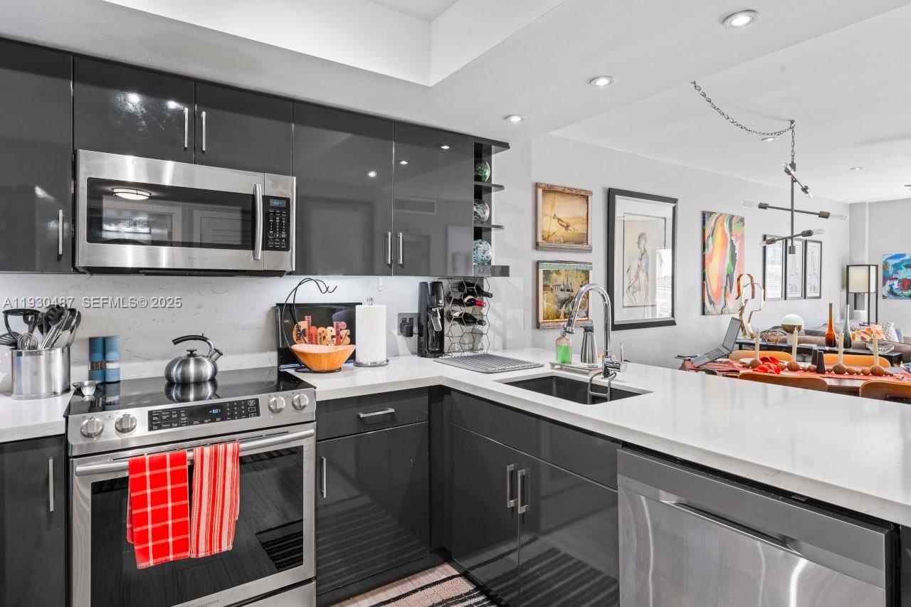 1450 Lincoln Road, Unit 307 Miami Beach, FL 33139 - Photo 7 of 18 a kitchen with stainless steel appliances a sink stove and microwave