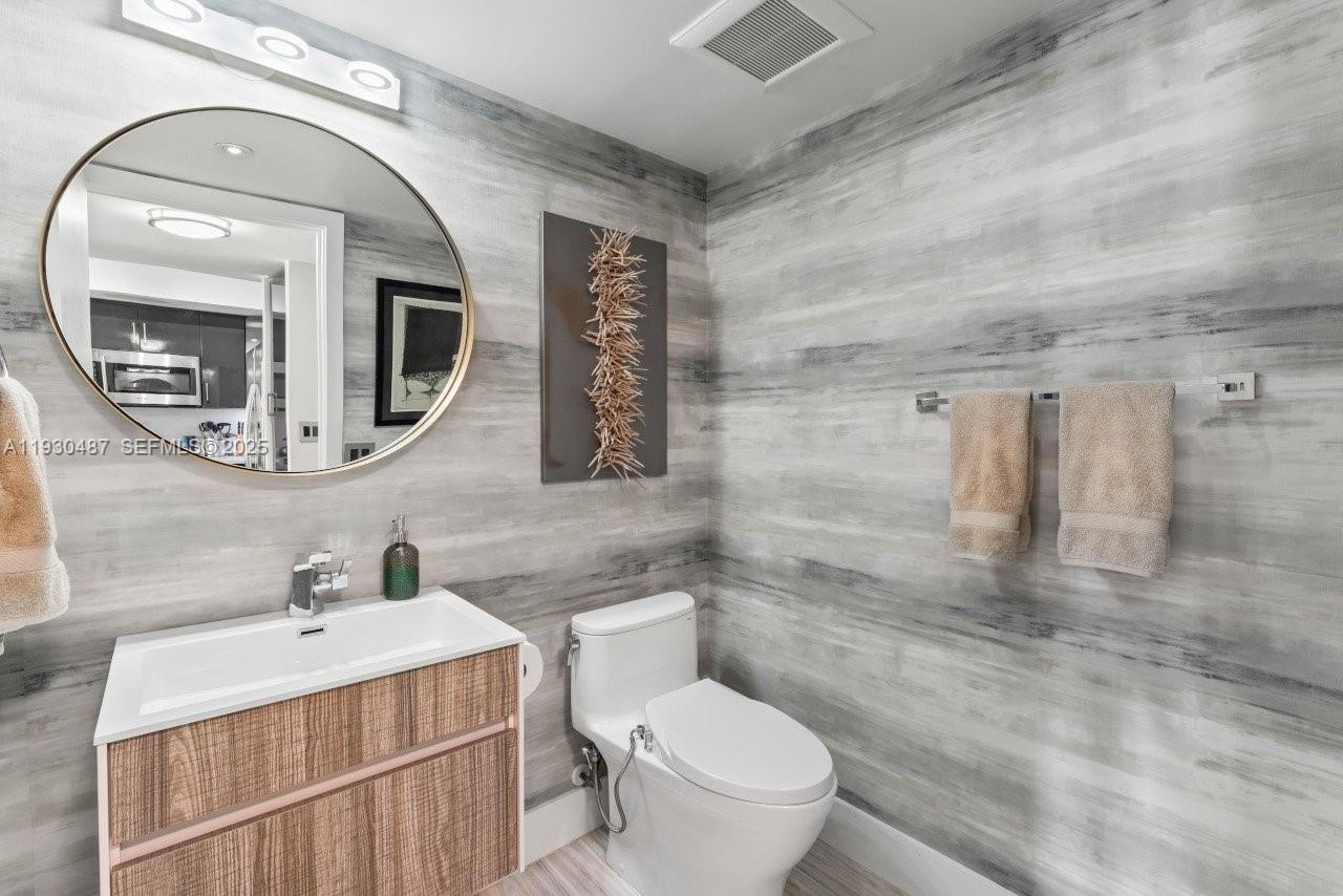 1450 Lincoln Road, Unit 307 Miami Beach, FL 33139 - Photo 9 of 18 a bathroom with a sink a toilet and mirror