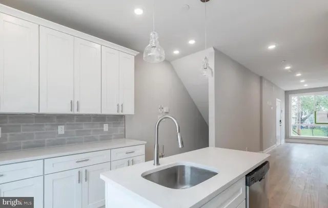 a kitchen with a sink a refrigerator and cabinets