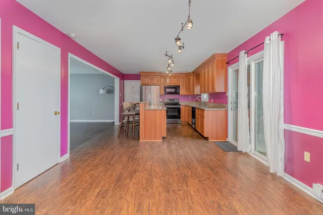 a open kitchen with stainless steel appliances granite countertop a refrigerator and microwave