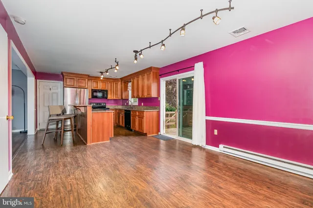 a open kitchen with stainless steel appliances granite countertop a refrigerator and microwave