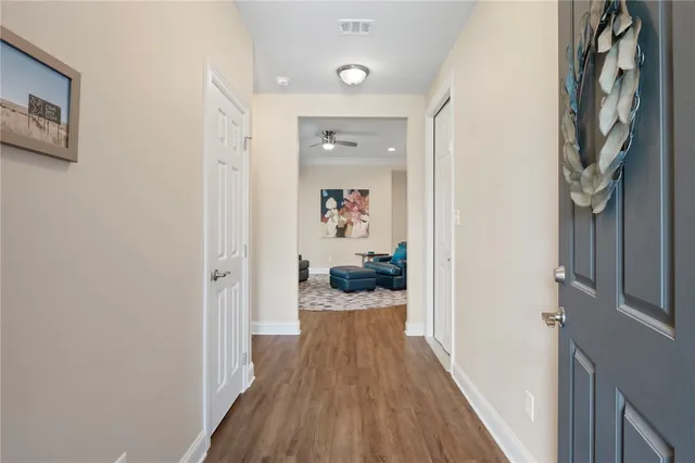 a view of a hallway with wooden floor and closet