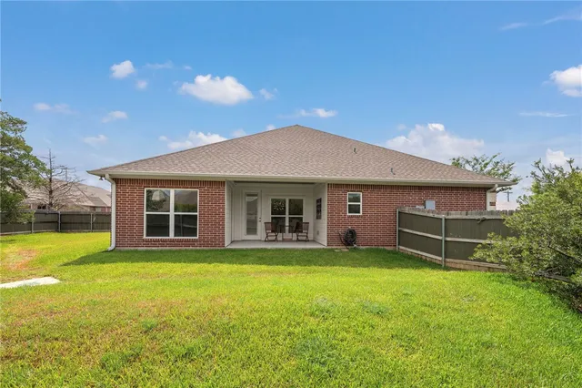 a view of a house with a yard and sitting area