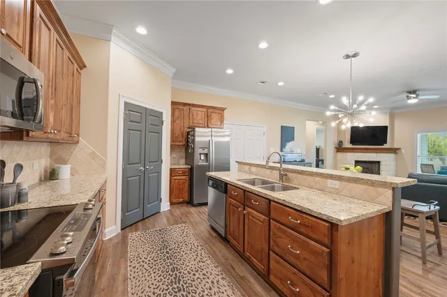 a kitchen with stainless steel appliances granite countertop a sink stove and refrigerator