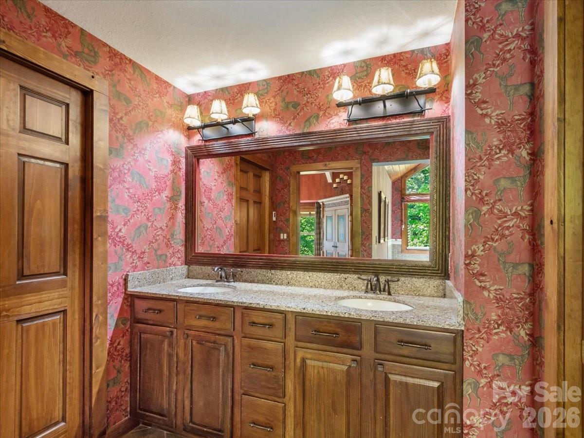 121 Ivy Ridge Road Burnsville, NC 28714 - Photo 21 of 48 a bathroom with a granite countertop sink and a large mirror