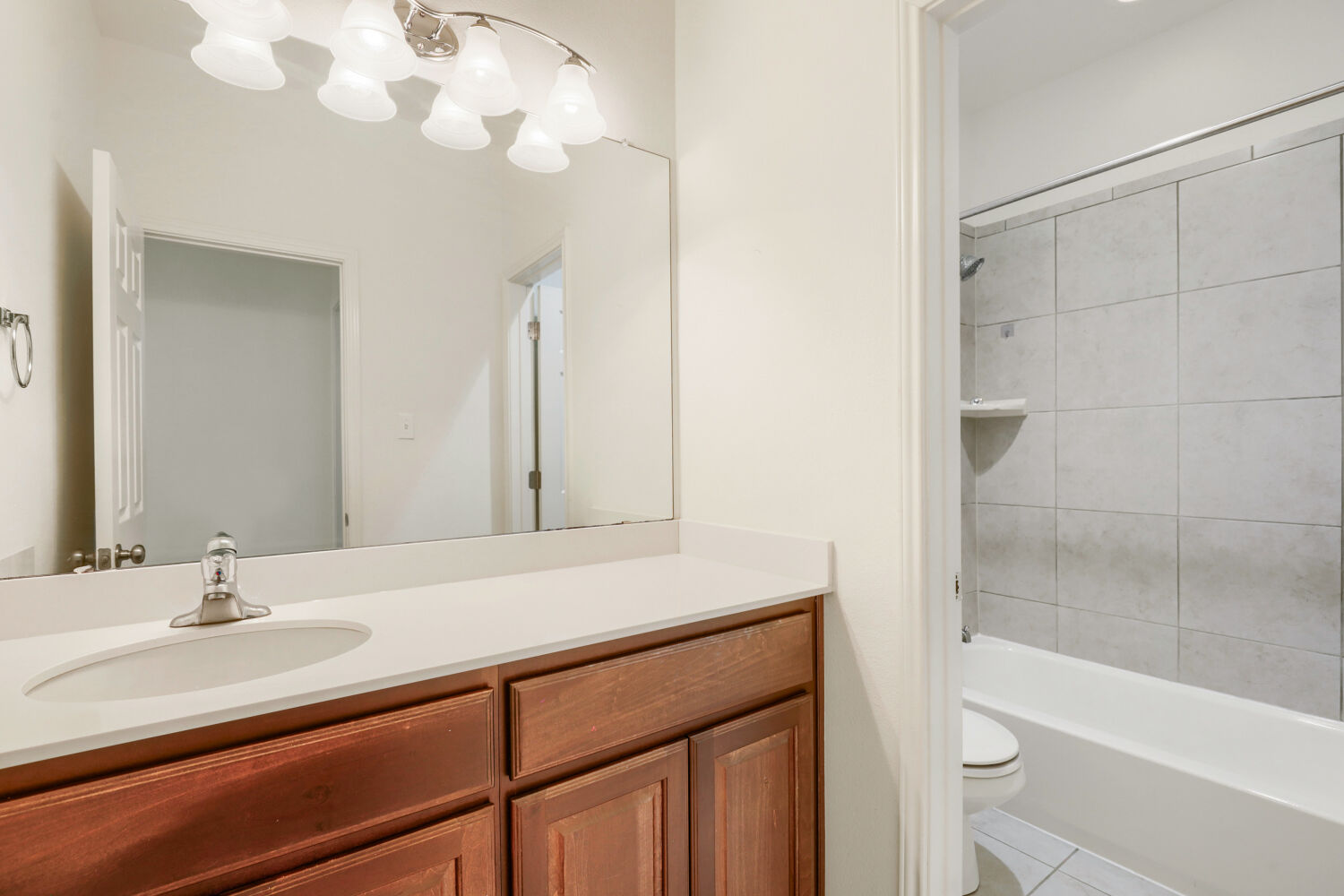 5821 Buchanan Draw Road Austin, TX 78738 - Photo 25 of 29 A well-appointed bathroom features a single vanity, ample mirror, and a tiled shower-tub combination.