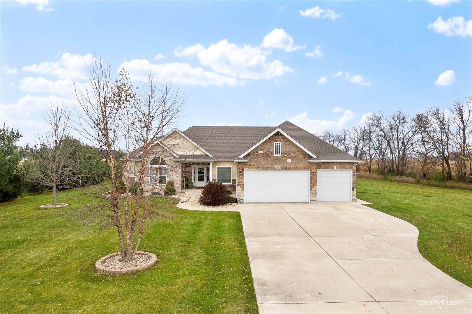 a front view of a house with yard and green space