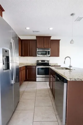 a kitchen with a sink a counter space and a wooden floor