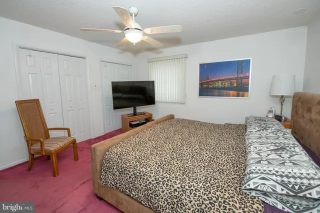 a bed room with a bed tv and a chair