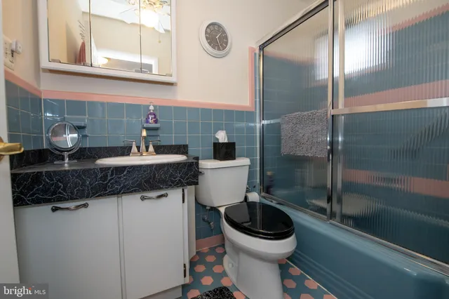 a bathroom with a granite countertop toilet sink and mirror