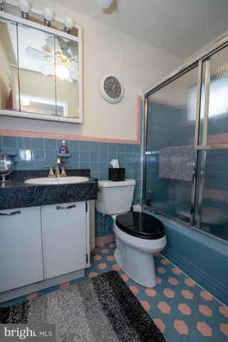 a bathroom with a granite countertop toilet a sink and a mirror