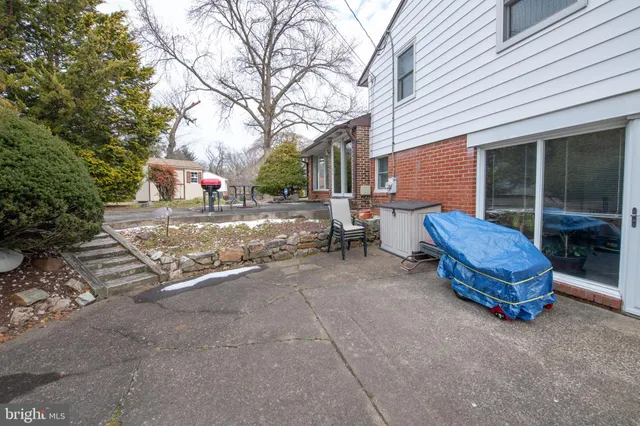 a backyard of a house with barbeque oven table and chairs