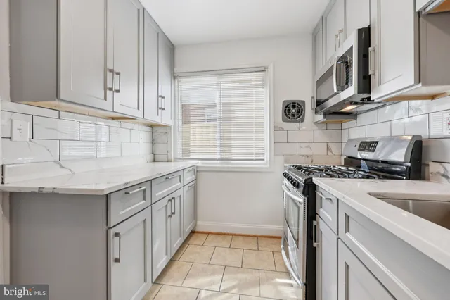 a kitchen with a sink stove top oven and cabinets