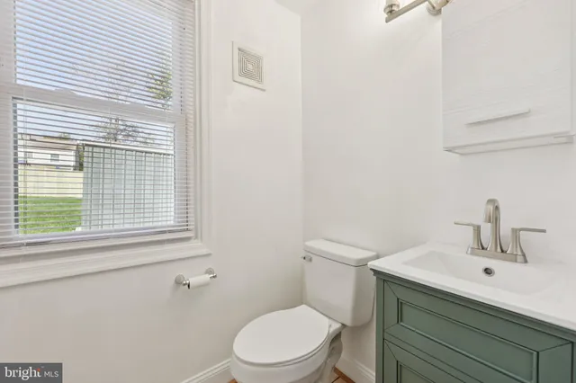 a bathroom with a sink a toilet and a window