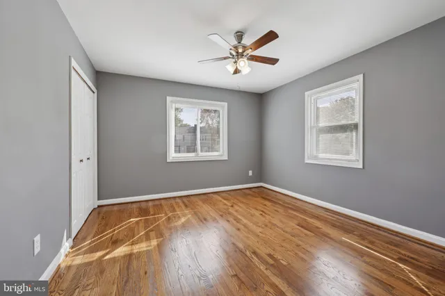 a view of a bedroom with wooden floor and a window