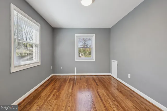 a view of a room with wooden floor and windows