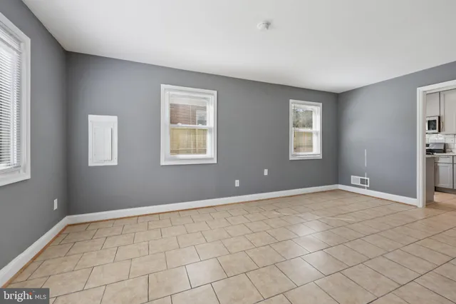 a view of an empty room with window and closet area