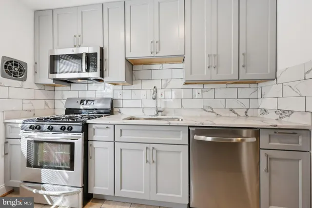 a kitchen with stainless steel appliances granite countertop a sink stove and microwave