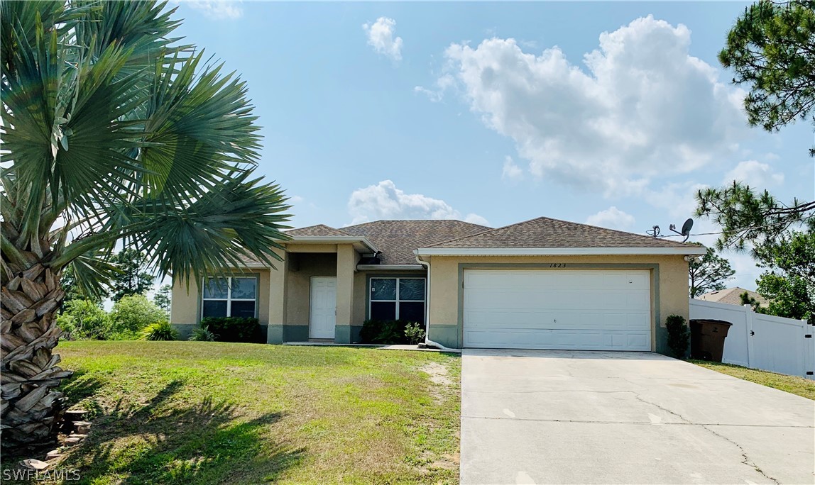 1823 Ridgemoor Street Lehigh Acres, FL 33972 - Photo 1 of 20 a front view of house with yard and trees