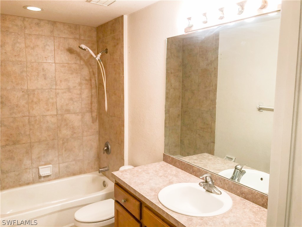 1823 Ridgemoor Street Lehigh Acres, FL 33972 - Photo 8 of 20 a bathroom with a granite countertop sink toilet and shower