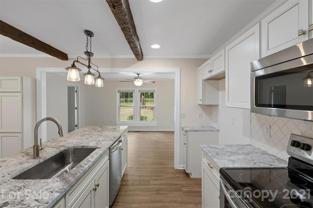 2665 Holbrook Road Fort Mill, SC 29715 - Photo 17 of 44 a kitchen with stainless steel appliances granite countertop a sink a stove and a wooden floors