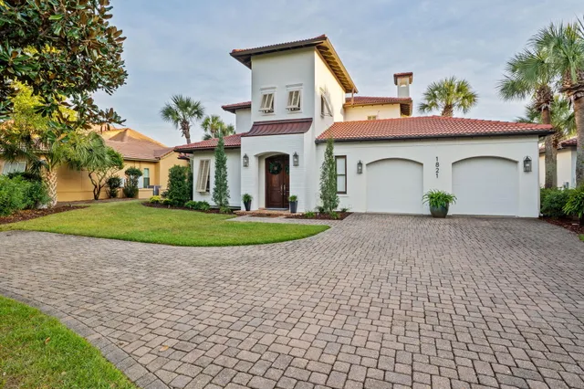 a dining room with wooden floor a chandelier a wooden table and chairs