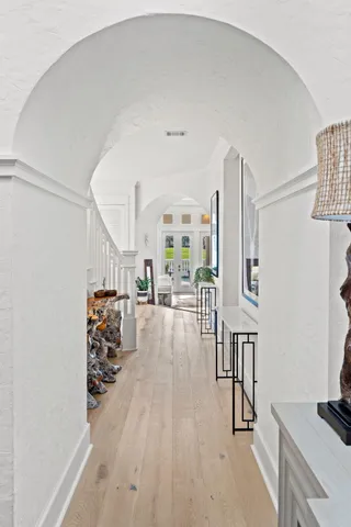 a view of a hallway with wooden floor and cabinet