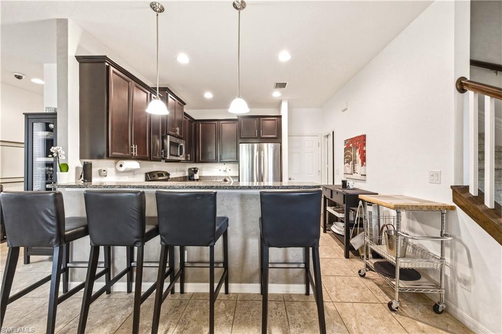 19540 Bowring Park Road, Unit 101 Fort Myers, FL 33967 - Photo 12 of 46 Kitchen with peninsula and barstools