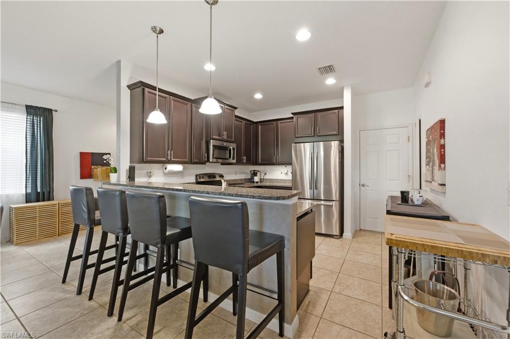 19540 Bowring Park Road, Unit 101 Fort Myers, FL 33967 - Photo 13 of 46 Kitchen with peninsula and barstools
