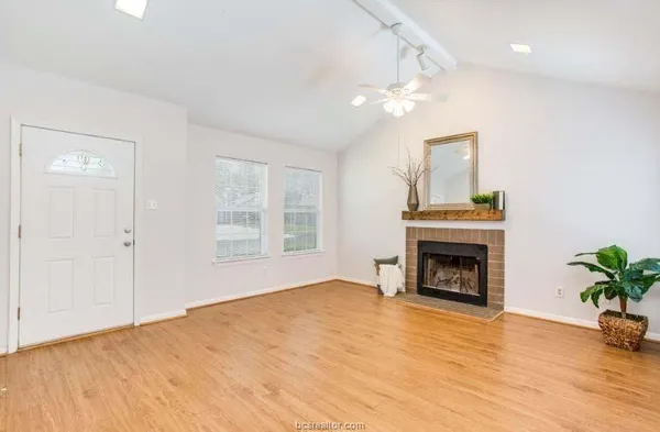 a view of empty room with a fireplace and wooden floor
