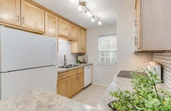 a kitchen with stainless steel appliances granite countertop a refrigerator sink stove and cabinets