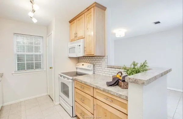 a kitchen with stainless steel appliances a sink a window and cabinets