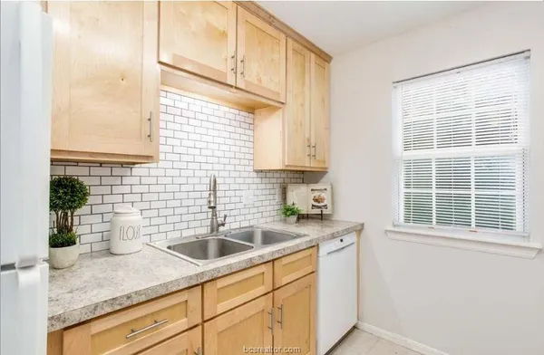 a kitchen with a sink a window and cabinets